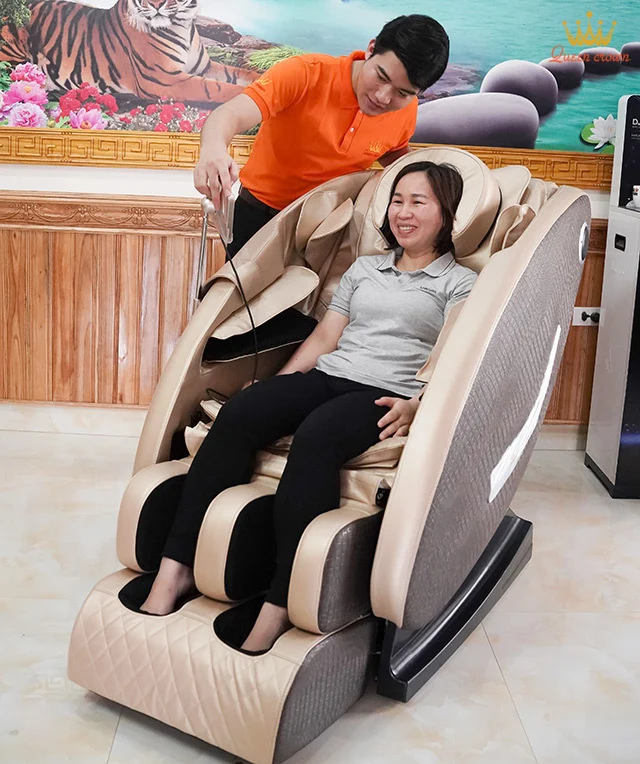 Chuyên viên Queen Crown hướng dẫn cô Quyên sử dụng ghế massage